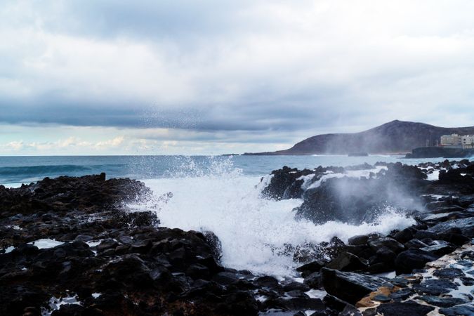 blue waves of ocean with foam texture against rocks