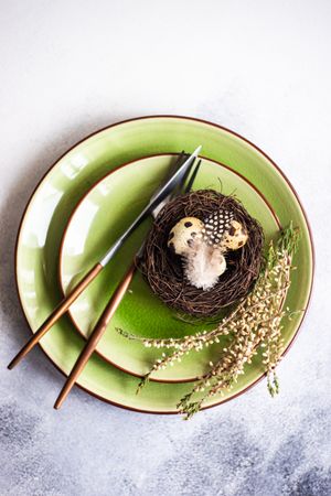 Top view of Easter table setting with decorative nest, with heather on green plates