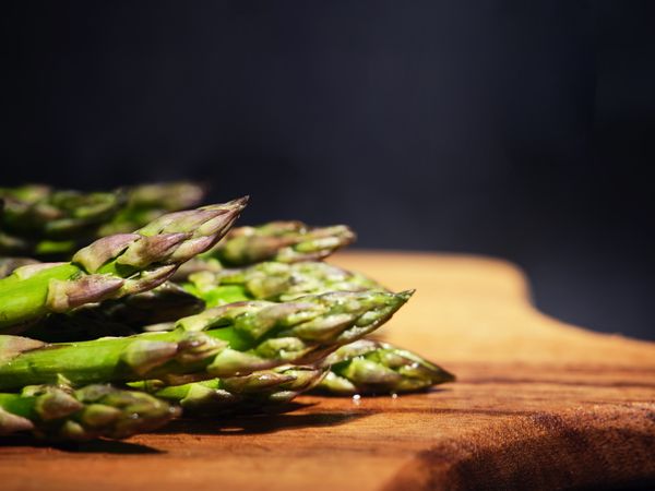 Heap of asparagus on chopping board