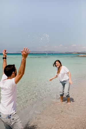 Cheerful lovers having fun on tropical coastline