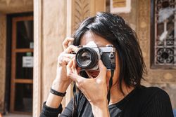 Female photographer taking picture with camera on street