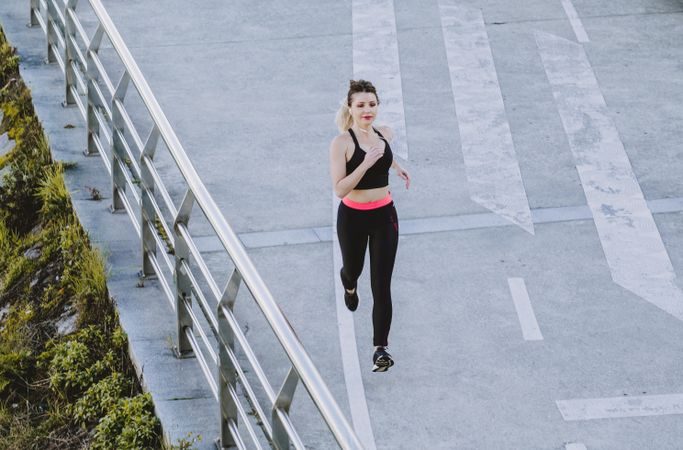Woman running on embankment near water