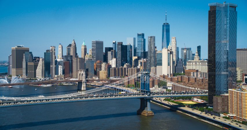Aerial Cinematic Drone Scene Near the Manhattan and Brooklyn Bridges with NY Skyscrapers Cityscape. Beautiful Sun Shining on a Warm Summer Day. Photo of Historic Architecture