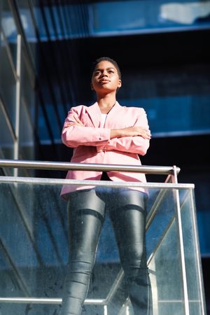 Proud woman in smart business attire standing tall outside building looking in distance