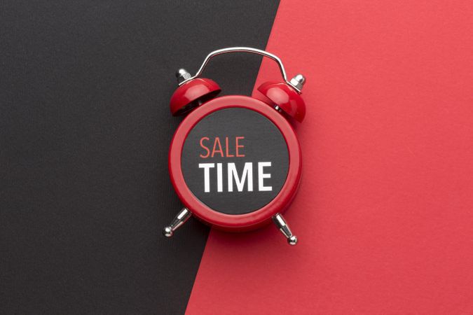 Alarm clock on red background with “Sale Time” on it
