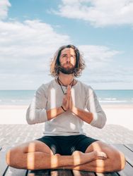 Man meditating on beach