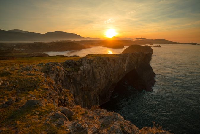 Majestic cliffs of ocean coastline in sunset