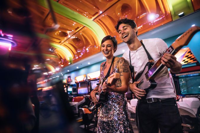 Couple enjoying a game of musical guitar at the gaming arcade