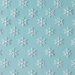Winter pattern made of uniform snowflakes on blue background