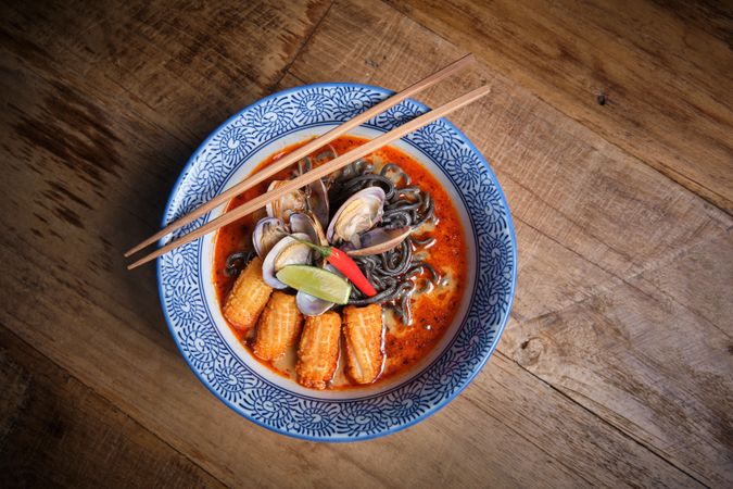 Typical hot ramen dish with fish broth in a bowl with noodles, squid, chilli, clams.