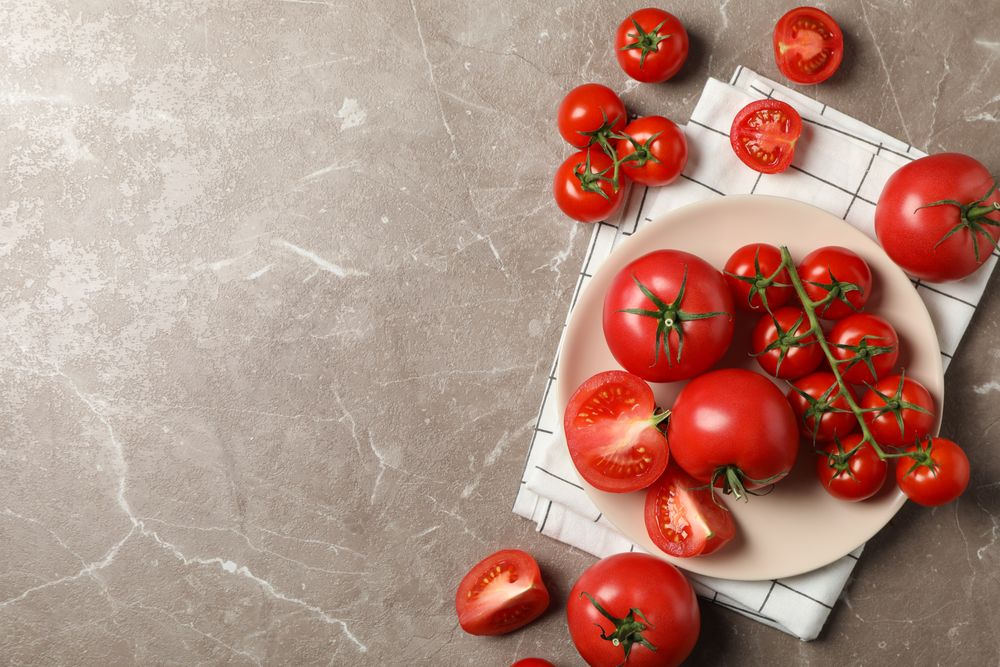 Composition with tomatoes on gray background, top view