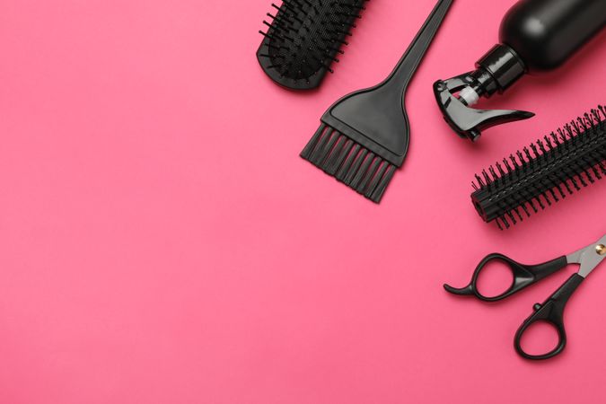 Composition with hairdresser accessories on pink background, space for text