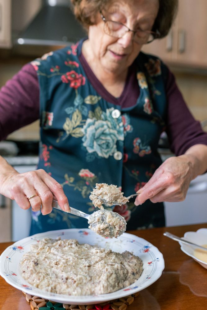 Patient woman coating croquettes dough with flour and egg