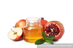 Pot of honey with dipper, open pomegranate and apples 5wJDZ0
