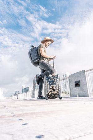 Full length portrait of hipster man with suitcase