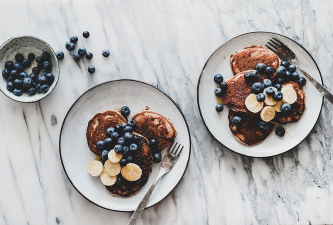 Pancakes with banana, blueberries on marble table