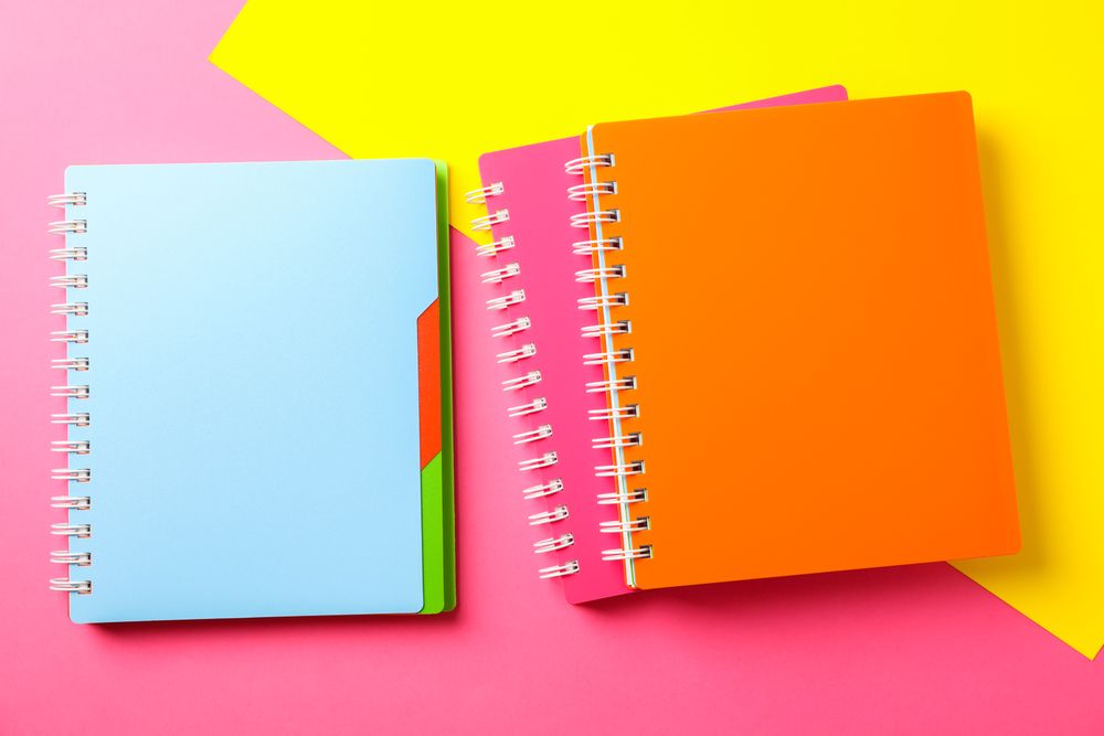 Composition with copybooks on two tone background, space for text