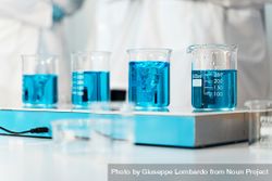 Beakers filled with blue liquid on a laboratory bench, highlighting scientific measurement and analysis bxAzaB