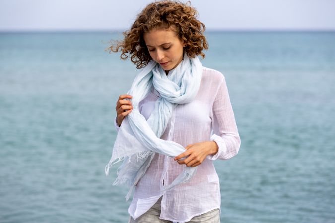 Young woman with sash near water