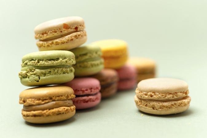 Pile of French pastel macaroons over a green background