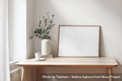 Empty horizontal wooden picture frame mockup with cup of coffee on wooden table bxARga