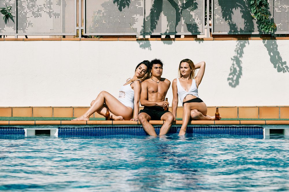 a group of young models by the pool in a summer day