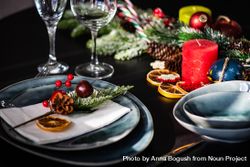 Christmas table setting with navy plate and seasonal branch 0gBPXb