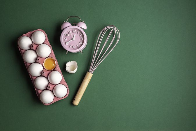 Baking flat lay with eggs, clock, and whisk