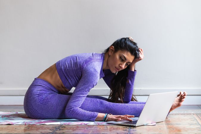 Flexible using laptop during yoga training at home