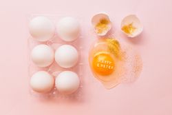 Easter eggs in box and broken egg on table