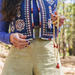 Close up of a woman holding a japa mala.