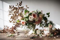 plate with cake decorated flower on table with bouquet of blooms in vase
