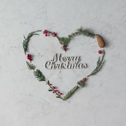 Heart shape made of winter foliage with the words “Merry Christmas”