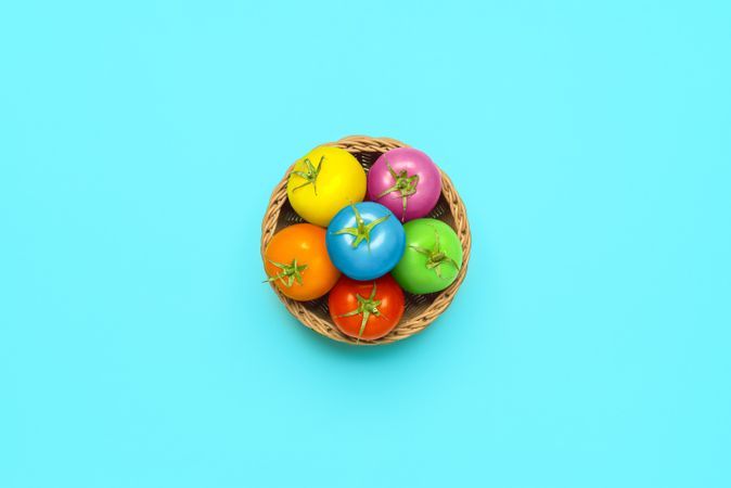 Easter concept with multi-colored tomatoes in a basket, top view