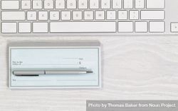 Blank checkbook with pen on desktop 0LkoRb