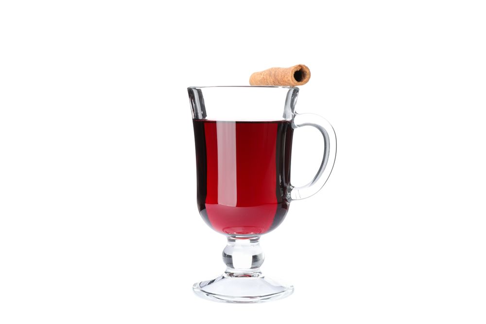 Glass of tasty mulled wine isolated on studio background