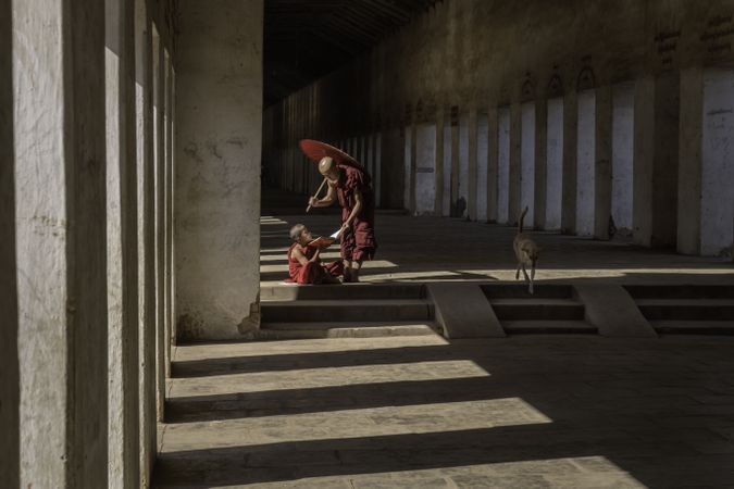 Buddhist monks sitting in a hallway in Myanmar