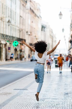 Black female jumping on urban background