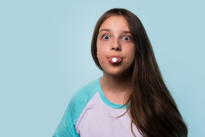 Girl playfully holds pill on her tongue