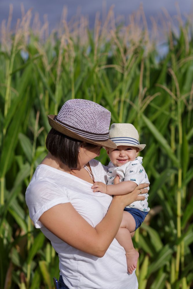 Adorable mother and child on hand enjoying and laughing in field