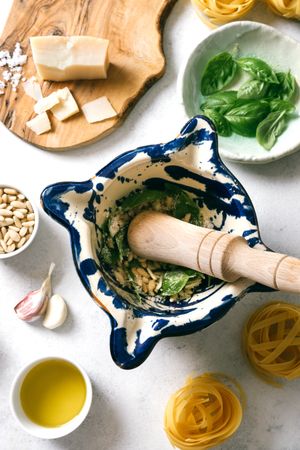 Pestle and mortar with ingredients for pesto sauce