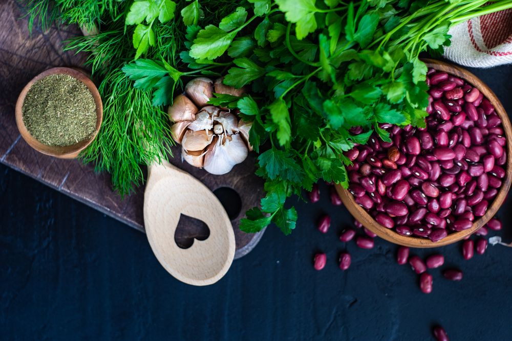 Kitchen counter with seasonings, herbs and dried beans and wooden spoon