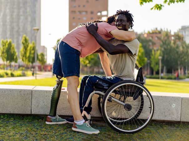 Men with disabilities embrace in a city park