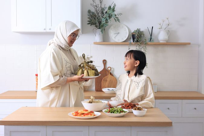 Mom and Daughter Preparing Ketupat Lebaran for Eid Al Fitr Celebration at Home.