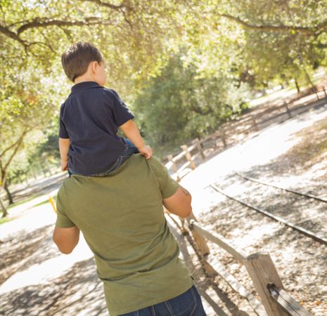 Son Enjoy a Piggy Back in the Park with Dad
