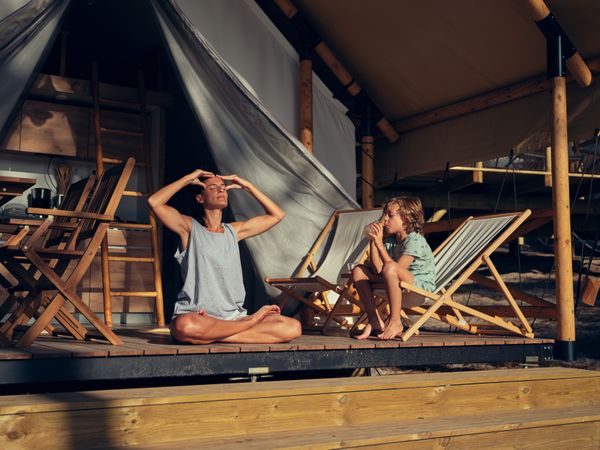 Woman massaging head near son on terrace