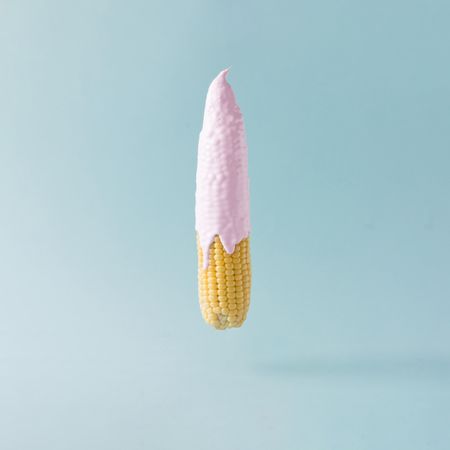 Corn with pink syrup on pastel blue background