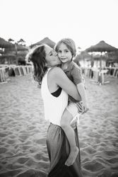 Mother kissing son on beach