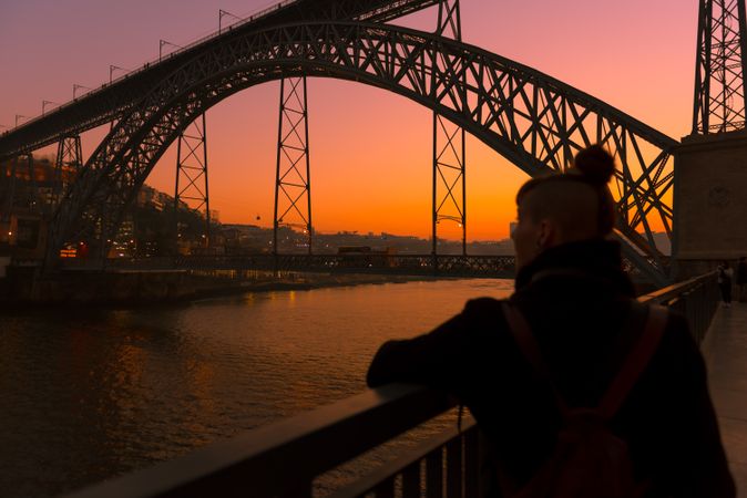 Woman looking at river and city in evening