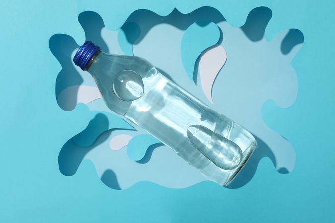 Looking down at full water bottle in swirly blue frame